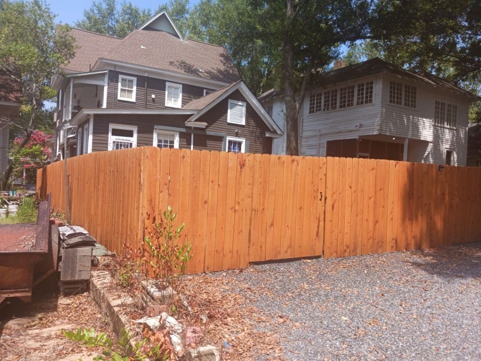 Finished wooden privacy fence closing off a side yard between two houses
